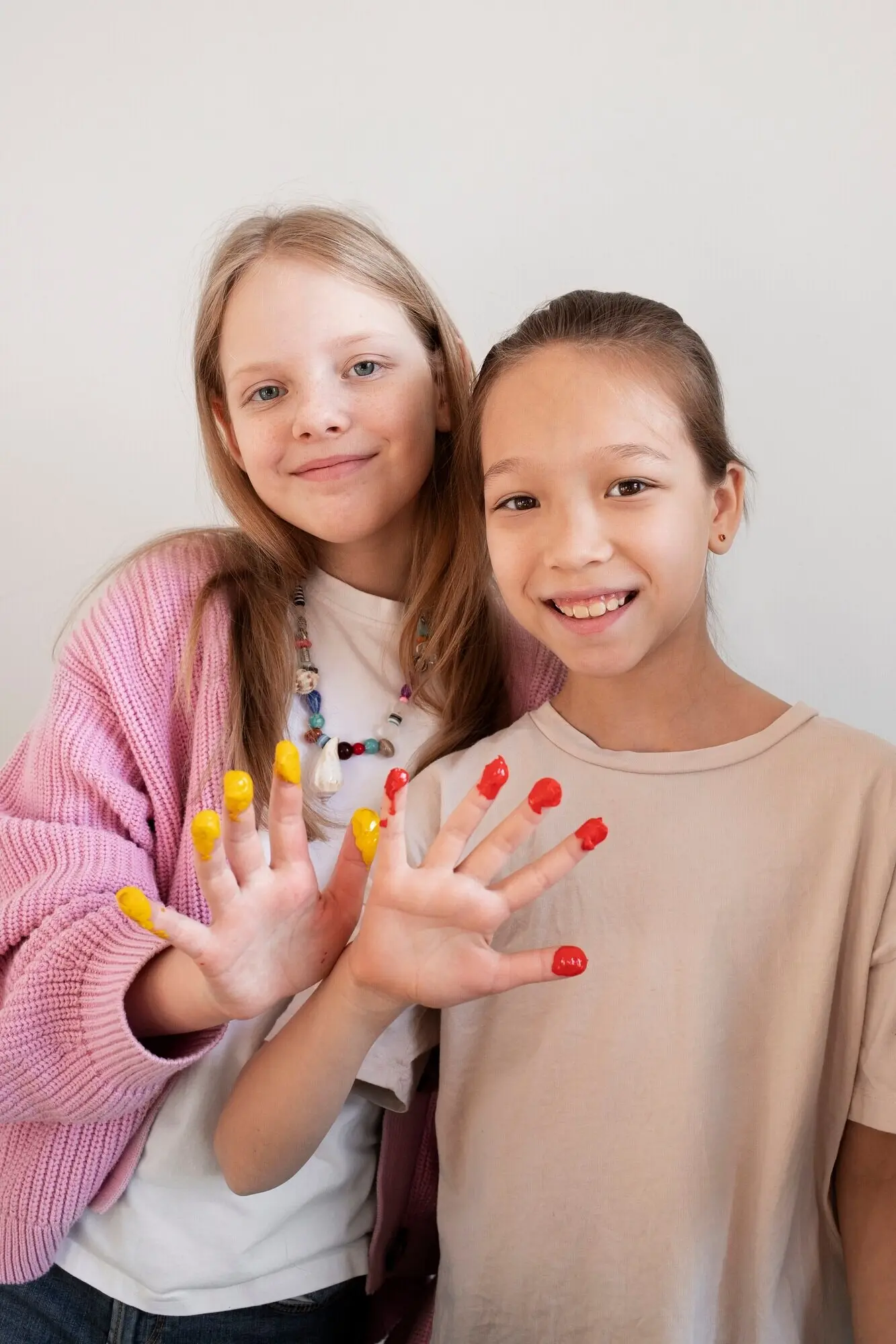 Junge Mädchen, die von einem DIY-Projekt Farbe an den Fingern haben.